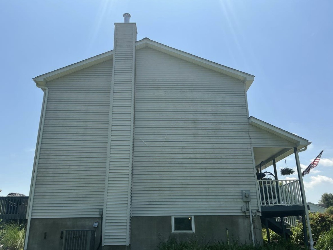 Dirty white vinyl siding on house exterior before soft wash